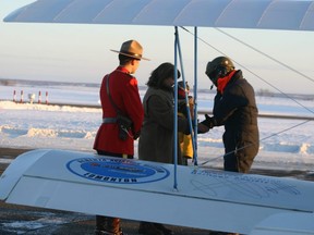 IMG_ 9290 – Bone-chilled stiff, open-cockpit Spirit of Edmonton pilot Curtis Peters, soon after exiting his cockpit, meets Laura Gloor, Museum curator, RCMP Const. Dave Brown, and young onlooker, at Peace River airport, February 10, 2009. Many others interested in aircraft and history wait inside a warm Northern Air Charter hangar to greet Peters and fellow pilot Tom Hinderks to learn more of their 80th anniversary re-enactment of May and Horner’s January 1929 Mercy Flight to Fort Vermilion in an open-cockpit bi-plane.