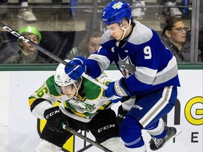 Chase Coughlan of the Sudbury Wolves leaps around Denver Barkey of the London Knights during their game at Budweiser Gardens in London, Ontario on Sunday December 17, 2023.