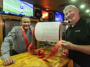 George Karigan, left, the owner of Eastside Pub and Grill on Hamilton Road, and Barry Travnicek are photographed with the 50/50 tickets sold at the London bar on Thursday Nov. 23, 2023. Mike Hensen/The London Free Press