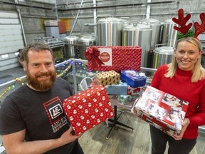 Anderson Craft Ales owner Gavin Anderson and the Shoebox Project's Michelle Stanescu show off some of the donated holiday gift boxes for women in need dropped off this week at the London craft brewer, one of 11 drop-off sites. Photograph taken on Thursday, Dec. 7, 2023. (Mike Hensen/The London Free Press)