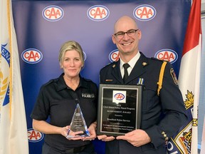 Kathryn Gratton, Civilian Elementary School Coordinator for the Brantford Police Service and Deputy Chief Jason Saunders show awards that were presented by the CAA South Central Ontario to the Brantford Police Service for their dedication to the CAA School Safety Patroller program.