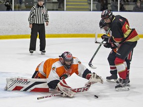 North Park Trojans goalie Cullen Goobie reaches for the puck beneath Carson Brown of the Paris Panthers during an AABHN high school boys hockey game on Tuesday December 5, 2023 at the Wayne Gretzky Sports Centre in Brantford, Ontario