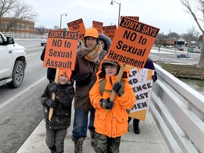 Erin Tewinkel, middle, and her sons Finn Tate, 6, left, and Miles Tate, 9, take part in the recent rally on Chatham's Third Street Bridge to mark the international day of elimination of violence against women.  (File/Ellwood Shreve/Chatham Daily News)