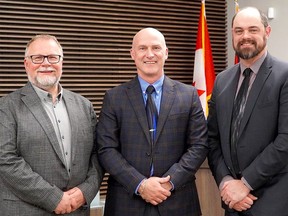 St. Clair Catholic District school board chair John Van Heck, left, and vice-chair David Argenti celebrate their acclamation to new one-year terms with education director Scott Johnson Tuesday night. (Supplied)
