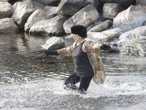 Grandmother Gail McTague dances her way into the 3oC Lake Ontario at Portsmouth Olympic Harbour for the third annual Kingston Grandmother Connection Polar Plunge in Kingston, Ont. on Sunday, Dec. 31, 2023.