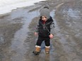 Issac Evoy, 2, plays in a puddle at Queen's Athletic Field in Sudbury, Ont. on Tuesday March 22, 2022. Outdoor facilities, like the skating oval at Queen's, are waiting for snow and colder weather. John Lappa/Sudbury Star/Postmedia Network