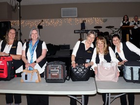 Rotarians (l-r) Danielle Merrifield, Julie Hemmerling, Annette Kay, Terri Dixon and Doreen Opsal displayed the various purses available at the live auction during Lobsterfest. The Rotary Club of Whitecourt held its annual fundraiser at St. Joseph Parish Hall on the night of May 6.