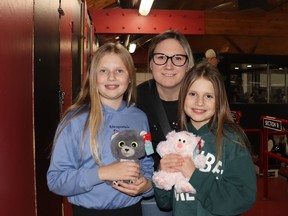 Piper, left, Kari Braun and Daylee brought stuffies to throw at the Teddy Bear Toss, held during the Whitecourt Wolverines game at JDA Place on Dec. 8. BRAD QUARIN