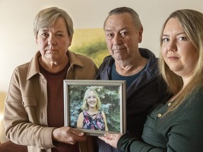 A photo of the late Karen Cunningham of Woodstock is held by her parents Margaret and William Cunningham and her sister Alyson. Photo taken on Jan. 16, 2024. Mike Hensen/The London Free Press/Postmedia Network
