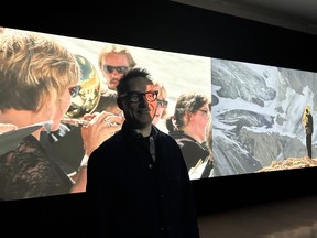 Paul Walde, an artist and composer, stands in McIntosh Gallery at Western University as his sound and video installation called Requiem for a Glacier is shown behind him. Photo taken on Friday, Jan. 19, 2024. (Beatriz Baleerio/The London Free Press)