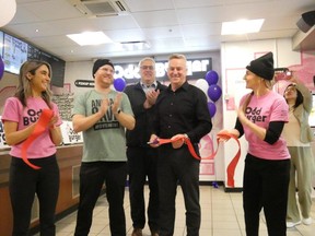 Vasiliki and James McInnes, left, co-founders of London-based Odd Burger, Matthew Davison, dean of science at Western University, Colin Porter, director of hospitality services at Western, and Odd Burger director of operations Katie McInnes cut the ribbon on the Odd Burger location that opened at the university on Monday, Jan.  22, 2024. (Jack Moulton/The London Free Press)