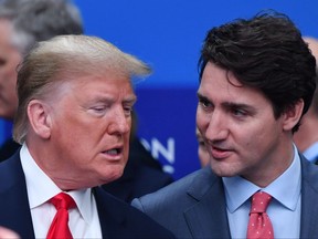 In this file photo taken on December 4, 2019, U.S. President Donald Trump (L) talks with Prime Minister Justin Trudeau during the plenary session of the NATO summit at the Grove hotel in Watford, northeast of London.