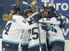 New York defender Ella Shelton (right) is congratulated by teammates Jamie Bourbonnais (14), Paetyn Levis (19) and Alex Carpenter (25) after scoring the first goal in PWHL history against Toronto during first period action in Toronto on Monday, Jan. 1, 2024. (THE CANADIAN PRESS/Frank Gunn)
