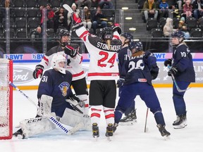 Canada's Abby Stonehouse (24) celebrates with teammate Sienna D'Allessandro (14) after scoring a first-period goal against Finland goalie Kerttu Kuja-Halkkola during the bronze-medal game at the 2024 IIHF U18 women's world championship on Sunday, Jan. 14, 2024, in Zug, Switzerland. (The Canadian Press/HO-International Ice Hockey Federation-Andre Ringuette)