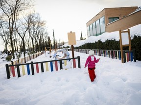 Stock photo of child looking at a snowy school playground