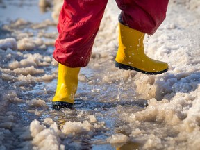 Stock photo of child jumping in a puddle of slush