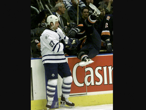 Toronto Maple Leafs player Shayne Corson bodychecks Roman Hamrlik of the New York Islanders into his team's bench during a 2002 game. (File photo)