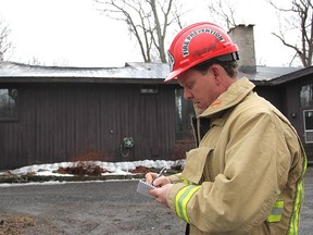 Fire inspector Del Blakney begins an investigation into a house fire north of Highway 2, east of the city, that heavily damaged the attic and roof of the home in November 2013.