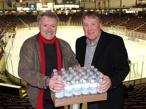 Sarnia Mayor Mike Bradley, left, and then Sarnia Sting president Bill Abercrombie hold a case of water bottles prior to an Ontario Hockey League game Jan. 23, 2016 in Sarnia to promote a water bottle drive for the citizens of Flint, Mich.