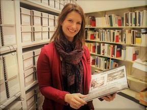 Archivist Nicole Aszalos holds photos in collections storage at Lambton County Archives.