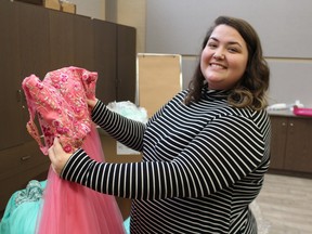 Katlyn Britton, with Sarnia-Lambton Rebound, holds a dress donated to the agency's former Cinderella Project program.