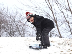Finn DeNoble, 8, slides down a hill at Robinson Playground in Sudbury, Ont. on Wednesday January 3, 2024.