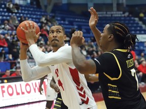 Andrew Whitsett, left, of the Sudbury Five, attempts to shot over Amir Yusuf, of the London Lightning, during basketball action at the Sudbury Community Arena in Sudbury, Ont.
