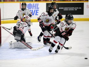 Jace Twigger scoops the puck up in front of the net following a Jack Harris save as the Owen Sound Attack under-11 team plays the Halton Hills Thunder at the Harry Lumley Bayshore Community Centre on Friday, Jan. 12, 2024. Greg Cowan/The Sun Times