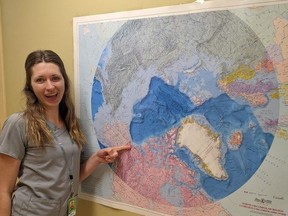 Danielle Jackson, an ultrasound technologist at London Health Sciences Centre, poses with a map of the Arctic at the regional hospital in Inuvik, Northwest Territories. Jackson did a three-week stint working at the underserved hospital in Canada's far north, an initiative LHSC is hoping to repeat in the future. (Contributed)