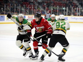 Sam McCue tries to split the defence of Landom Sim (90) and Jackson Edward in the first period as the Owen Sound Attack play the London Knights inside the Harry Lumley Bayshore Community Centre on Saturday, Feb. 17, 2024. Greg Cowan/The Sun Times