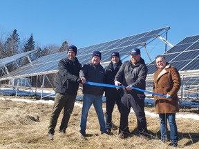 Jesse Mitham, second from right, prepares to cut the blue ribbon with Bruce Mitham of Rothiemay Farms, second from left, as well as the Smart Energy Company's CEO Mark McAloon, centre, Jeff McAloon, chief development officer, left, and Saint John-Rothesay MP Wayne Long, right. The Quispamsis-based firm opened its micro solar farm kit at the Norton farm Tuesday.