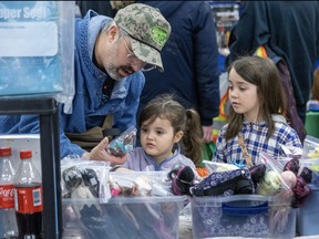 Adam Schlegel helps his daughters Starla, 4, and Sandy, 6, select a toy at the London Toy and Collectibles Expo at Centennial Hall on Sunday February 25, 2024. Derek Ruttan/The London Free Press
