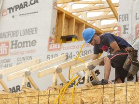 Construction worker Jacob Griffin puts up baby trusses overtop a porch on a home being built in London. (Free Press file photo)