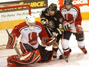 London Knights player Logan Hunter battles for the puck against the Windsor Spitfires in an Ontario Hockey League game in March 2004.