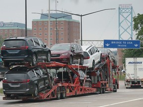 A truck carrying newly built Windsor Chrysler Pacificas heads to the Ambassador Bridge in Windsor on Tuesday, June 27, 2023.