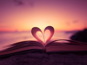 Stock photo of sunset framed by pages in shape of a heart