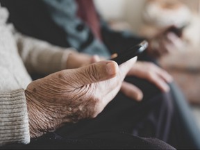 Stock photo of elderly hand holding cellphone