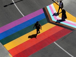 Pedestrians make their way across a Pride crosswalk outside Kingsway Mall in Edmonton on June 6, 2023.