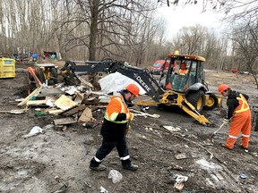 Kingston city workers clear debris from a homeless encampment