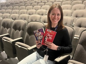 Adrianne Lebert with Lambton Library poses in the Sarnia Library Theatre with Tessa Bailey books