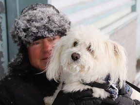 Harry Will cuddles with Oliver the dog while getting some fresh air at Bell Park in Sudbury, Ont. on Thursday February 15, 2024. John Lappa/Sudbury Star/Postmedia Network