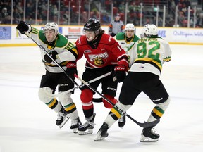 Sam McCue tries to split the defence of Landon Sim (90) and Jackson Edward in the first period as the Owen Sound Attack play the London Knights inside the Harry Lumley Bayshore Community Centre on Saturday, Feb. 17, 2024. Greg Cowan/The Sun Times