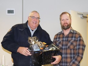 Sgt. Bob Dodds, left, received a package from Woodlands County Reeve Dave Kusch in thanks for his service. Dodds was detachment commander of the Barrhead RCMP and is retiring.
