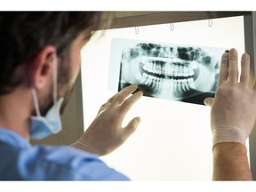 illustration - dentist looking at Xrays of teeth