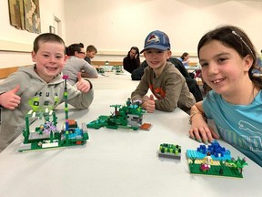 From left, Eli Robinson, 5, Luke Robinson, 7, and Anna Hewson, 10, with their creations they made during the Owen Sound and North Grey Union Public Library's LEGO building competition in the auditorium on Wednesday, December 27, 2023.