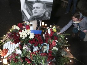 People leave flowers and candles as members of the Russian Action Network for Democratic Organizing and Mentoring and the local Russian community during a memorial for late Russian opposition leader Alexei Navalny at the "Peace Pole" next to the Space Needle in Seattle, Washington on March 1, 2024.