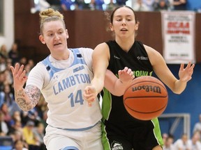 Lambton Lions' Brett Fischer (14) and Algonquin Wolves' Libby Hirst (11) battle for a rebound during the OCAA women's basketball final at Lambton College in Sarnia, Ont., on Sunday, March 3, 2024. Mark Malone/Chatham Daily News/Postmedia Network