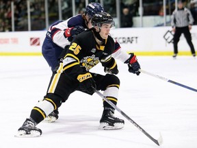 Sarnia Sting's Tyson Doucette (25) tries to get past Saginaw Spirit's Will Bishop (4) at Progressive Auto Sales Arena in Sarnia, Ont., on Friday, March 22, 2024. Mark Malone/Chatham Daily News/Postmedia Network