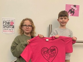 Tessa Foley and Jack Fryer, students at Davidson Creek Elementary, hold up a pink shirt that features student designs inspired by Pink Shirt Day and the school’s motto: A place where we belong.