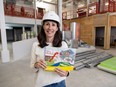 Kate Ledgley, executive director of the London Children’s Museum, holds a rendering of the Farm Works exhibit under construction behind her in the museum’s future home at 100 Kellogg Lane in London on Friday, March 22, 2024. (Derek Ruttan/The London Free Press)